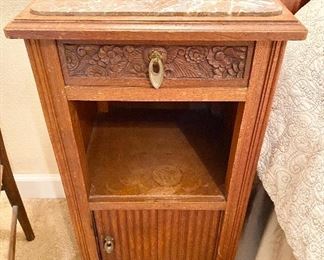 Antique Marble Top Bedside Cabinet with Carved Top Drawer and Sliding Bottom Drawer. Brass Hardware. Measures 32" tall x 16" wide x 16" depth.