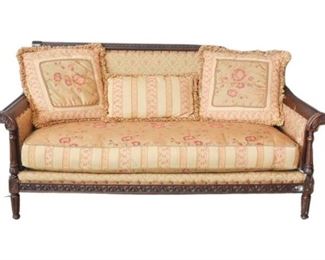 2. Upholstered Settee With Carved Wood Details and Accent Pillows