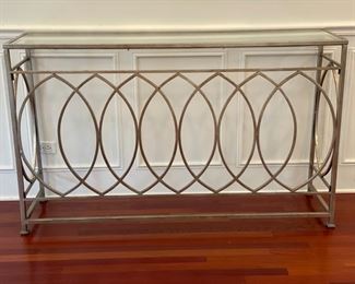 Uttermost gold metal console with glass top. Measures 60" W x 16" D x 36" H. Photo 1 of 2.