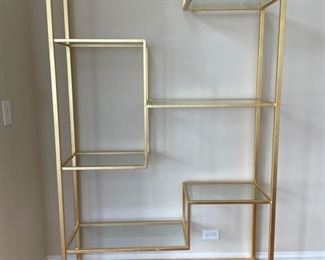Frontgate gold metal modern bookshelf with tempered glass shelves. Measures 48" W x 14" D x 80" H.