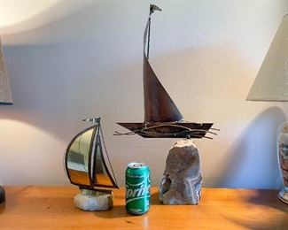 LOT #142 - $50 - Lot of 2 Metal Sailboat Sculptures Mounted on Rocks (lot includes both, the smaller is signed Demott, the larger is unsigned)