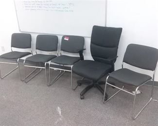 5 office chairs, 4 grey and silver, 1 black with wheels