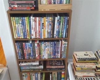 Large Collection of DVD's  Children and Adult Movies. Books Collection on the plastic white shelf rack stand.