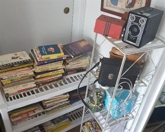 Books Collection of Small Long White Plastic Stand. Tall Metal Rack Open Shelves, 5 Shelves. Vintage Cameras, Binoculars and More. Two Angels Dancing Picture.