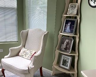 A corner shelf and wing back chair  
