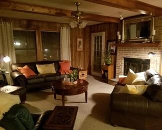 The living room contains several pieces of leather furniture