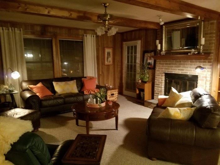 The living room contains several pieces of leather furniture