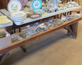 ANTIQUE PINE BENCH WITH BAGS OF FURNITURE HARDWARE ON IT.