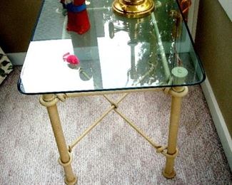 One of a pair glass & wrought iron end tables.