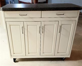 Handy cabinet on rollers has counter top 