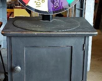 Small cabinet has drawer & door and "spin to win" wheel