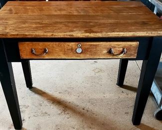 Sturdy table has natural wood top & drawer & black painted legs