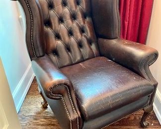 $600; leather wing-back chair with scrolled top and tufting with claw feet; 32”w x 32”d x 44”h