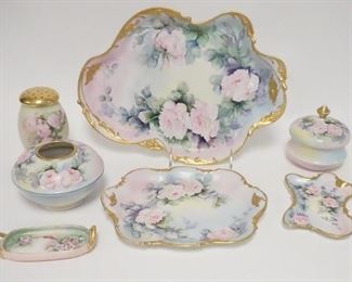 1009	7 PIECE HAND PAINTED PORCELAIN DRESSER SET, LIMOGES & OTHER BLANKS, PAINTING BY M.D. CHANDLER ROCHESTER, NY, BOTTOM OF THE HATPIN HOLDER IS BROKEN OUT, LARGEST TRAY IS 12 3/4 IN
