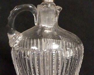 1064	CUT GLASS JUG W/STERLING SILVER OVERLAY STOPPER, HAS RIM CHIPS & A CHIP ON THE UNDERSIDE, 8 IN HIGH
