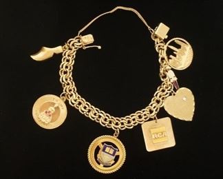 1172	14K CHARM BRACELET, RCA CHARM MARKED 10K, SHOE AND UPSLA COLLEGE CHARMS MARKINGS NOT FOUND, OTHERS MARKED 14K ONE WITH 3 RUBIES OR GARNETS, ONE WITH DIAMOND CHIP. 7 IN LONG, 40 DWT
