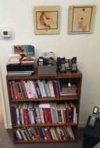 There are books here, as well as a bookcase or two.  Notice the artwork on the wall  behind the bookcases.
