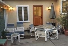 The patio set (table, side table, chairs, lounges, and umbrella) is shown in this photo.