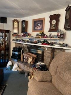 Regulator style pendulum clocks over the fireplace and  Diecast Collectible cars  1:24 1:16  1:12 on the mantel. 