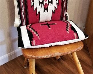 Log chair and red and black pillows.