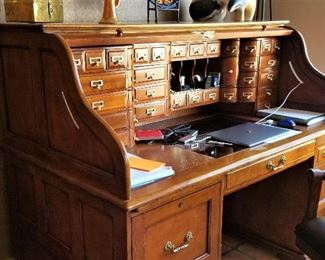 Roll top desk with lots of drawers.