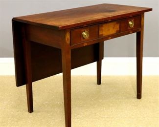 Lot 6: A late 18th century British George III Period side table.  Mahogany construction with single drop leaf, gate-leg support, and straight skirt with incorporated drawer and three paneled façade, inlaid decoration and Brass ring pulls, on simple tapered legs.  Older finish with minor wear, some staining on top.  36 x 19 (38 1/4" open) x 28 1/2" high overall.  ESTIMATE $400-600