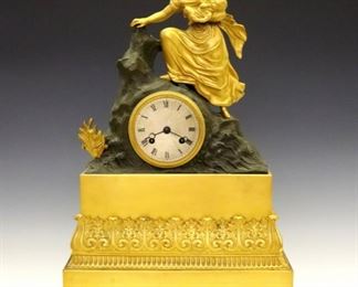 Lot 8: An early 19th century French Empire Period mantel clock.  Figural Bronze case featuring Leto, the Goddess of Motherhood on a rocky island outcropping, over an intricate Gilded Bronze base.  8-day time and strike movement with an engine turned Silvered dial and Roman numerals, original silk thread suspension converted to a hanger.  Minor surface wear, running momentarily when cataloged.  17 3/4" high.  ESTIMATE $600-800