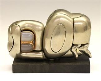Lot 10: Miguel Ortiz Berrocal, Spanish, 1933-2006.  A 1960's polished metal and moonstone puzzle sculpture, titled "Mini Zoraida".  Includes twenty-three pieces and original resin stand.  Incised "Berrocal" signature and "3034" from the edition of 9500.  Minor surface wear.  Approximately 3 1/2 x 1 1/4 x 1 3/4" high overall plus stand.  ESTIMATE $400-600  NOTE: Includes the instruction book "La Mini Zoraida: Hommage a Paloma. Instructions for Assembly". 