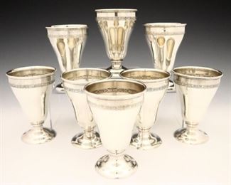 Lot 15:  Eight Elgin American Manufacturing Sterling Silver goblets.  Footed with floral bands along inner and outer cup edge.  Marked "E.A.M." and "Sterling" with model numbers.  32.25 troy ozs total weight.  Minor surface wear.  Each 5 3/4" high.  ESTIMATE $600-800