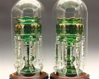 Lot 34: A pair of 19th century British mantel lustres.  Deep Emerald Green glass with scalloped tops and baluster bases, original Gilded detail with enameled floral decoration and two rows of cut glass prisms.  In remarkable condition with the original glass domes and wooden bases, some flakes to prisms.  Each 14" high, 20" high overall including dome and base.  ESTIMATE $800-1,200