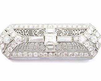 Lot 41: An Art Deco era Platinum and Diamond brooch.  Consisting of 1 center square diamond of 0.55 cts, 4 accent diamond baguettes, 0.56 cttw, and 54 round diamond accents, 4.34 cttw.  Stamped "Plat.".  10.0 grams total weight.  Some surface wear to platinum.  1 3/4" long.  ESTIMATE $2,000-3,000  