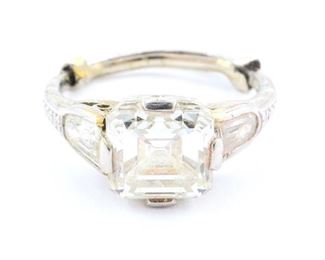 Lot 44: An Art Deco style Platinum & Diamond engagement ring.  Consisting of 1 center emerald cut diamond measuring 7.1 x 7.3 mm, approximately 2.25 cttw, with estimated F/G color and VS1 clarity, flanked by two baguette diamonds, approximately 0.50 cttw, set with 2 small diamonds at sides, approximately 0.06 cttw.  Unmarked, but tested platinum.  3.7 grams total weight.  Some surface wear and buildup.  Size 5 1/2 without sizer.  ESTIMATE $2,000-3,000  