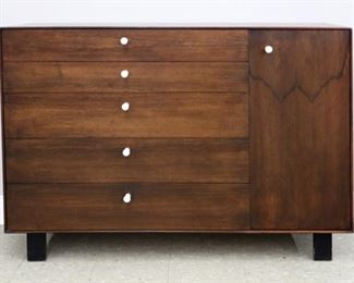 Lot 59: A mid 20th century George Nelson for Herman Miller "Thin Edge" cabinet.  Rosewood construction with a large cabinet flanked by five side drawers, each with original white Porcelain knobs, raised on Black wooden legs.  Minor wear, slight loss to finish at edge.  55 3/4 x 18 3/4 x 39 1/2" high overall.  ESTIMATE $1,000-2,000