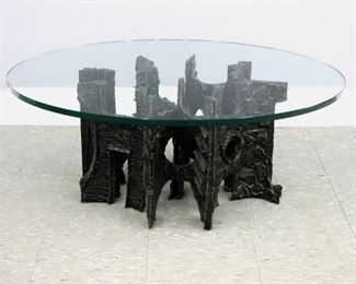 Lot 61: A mid 20th century Brutalist style coffee table in the manner of Paul Evans (American, 1931-1987).  Sculpted Bronze tone composite over Steel construction with dark patina and thick circular glass top.  Unmarked, some surface wear and scratches, glass edge with shallow chip.  42" diameter top, base approximately 27 x 26 x 15" high overall.  ESTIMATE $1,000-2,000