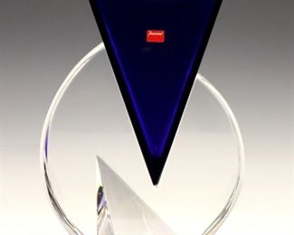 Lot 65: A 1990's Baccarat Crystal "Vecteur" vase.  Two-part design features a triangular vase in Cobalt Blue resting in a conforming colorless base.  With etched "Baccarat" signature and original foil sticker.  Minor wear, minor surface abrasions at union points between sections.  8 1/4 x 2 3/4 x 10" high overall.  ESTIMATE $300-500