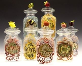 Lot 69: Eight turn of the century Italian Venetian glass apothecary jars.  Colorless glass jars with multicolor blown glass fruit form covers and hand-painted polychrome labels.  Some wear to painted labels.  Up to 13" high.  ESTIMATE $800-1,200