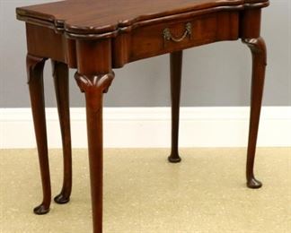 Lot 75: An 18th century British George II Period games table.  Mahogany construction with shaped top and conforming base, top opens to reveal a restored felt gaming surface with corner candle stands and carved guinea pockets, over a shaped skirt with turret corners and single dovetailed drawer, on tall cabriole legs with carved knees and pad feet.  Repolished with good color and slight wear.  34 1/2 x 17 (34" open) x 29" high overall.  ESTIMATE $1,000-2,000