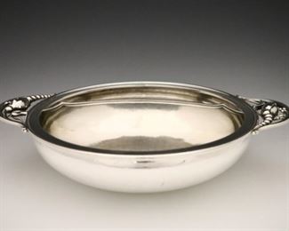 Lot 82: A Georg Jensen "Blossom" pattern Sterling Silver bowl.  Art Nouveau style with two floral handles and divided interior.  Marked "Georg Jensen, Denmark, Sterling".  38.15 troy ozs total weight.  Minor surface wear, light scratches and dents.  12 x 2 3/4" high overall.  ESTIMATE $1,000-2,000