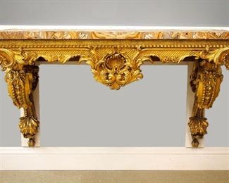 Lot 85: A Good 19th century Giltwood console table.  Book-matched specimen Marble veneered top on a carved Giltwood base with Gesso detail, features a shaped skirt with basket work design and gadrooned molding with a central shell, and foliate drop supported by two wall brackets with scrolled foliate design.  Old finish with some touch-ups and minor repair, several repairs to the Marble top.  Minimum 54 1/2 x 28 x 34 1/2" high overall.  ESTIMATE $2,000-4,000