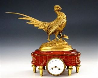 Lot 84: A 19th century French Louis XVI style Bronze and Onyx clock with a pheasant sculpture by Paul-Édouard Delabrièrre (French, 1829-1912).  Swiss 8-day 11j time and strike movement with platform escapement, serial #1136, with a convex porcelain dial, Arabic numerals and engraved golden hands.  Speciman grade Rouge Onyx base with Gilded Bronze pheasant, beaded moldings and gadrooned legs.  Slight wear, running when cataloged.  14 1/4" high.  ESTIMATE $3,000-5,000