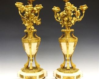 Lot 94: A pair of 19th century French Louis XVI style candelabra.  Gilded Bronze and Marble construction with four upper floral arms, cast ram's head decoration and tripod base.  Some surface wear and losses to florals, missing one flower and several leaves.  Each 17 3/4" high.  ESTIMATE $1,000-1,500