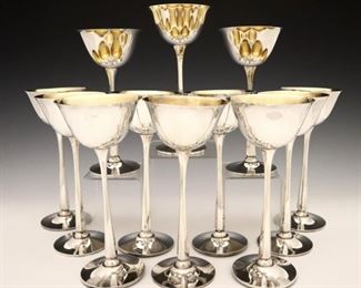 Lot 16: Twelve Graff, Washbourne & Dunn Sterling Silver wine glasses.  Fluted hexagonal stems with Gold washed interior.  Each with maker's mark, "Sterling" and model numbers.  60.73 troy ozs total weight.  Minor surface wear, one cup lacks Gold wash, wear to Gold wash on others.  Each 7 3/8" high.  ESTIMATE $1,000-1,200