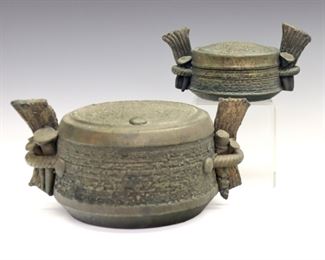 Lot 130:  Two late 20th century Art Pottery pieces by Ron Artman.  Short cylindrical forms with Bronze/Gray finish, basketweave texture, and applied side handles.  Incised "Artman" signatures at undersides.  Minor wear.  Up to 10 x 4 1/4" high overall.  ESTIMATE $100-200