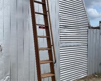 Vintage tall industrial wooden ladder with a side handle bar that was used to service relay panels at telephone exchange locations. 