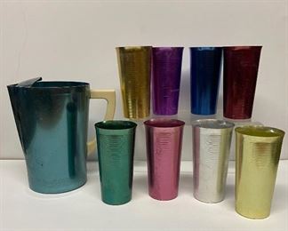 A vintage set of colorful aluminum drinkware and pitcher by West Bend 