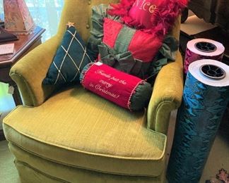 Bedroom chair with Christmas pillows; rolls of wrapping paper