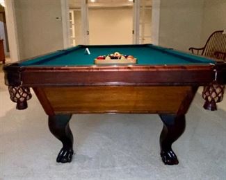 Lot 9002-A $1595.00. AMF 8' Pool Table, Stately table crafted in cherry, with green felt table  and sides, leather pockets, claw and ball feet, includes balls, triangle, all accessories, 4 pool cues and a bridge. If you've been looking for a pool table that looks as great as it plays, this is your table!