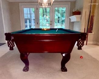 Lot 9002-A $1595.00. AMF 8' Pool Table, Stately table crafted in cherry, with green felt table  and sides, leather pockets, claw and ball feet, includes balls, triangle, all accessories, 4 pool cues and a bridge. If you've been looking for a pool table that looks as great as it plays, this is your table!