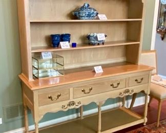 Lot 9095. $275.00  Weiman Pickled Oak Side Board and Hutch.  Sideboard has three pull out drawers, scalloped trim below that and a base open shelf above the leg knobs and it appears to have a couple stencils .  Hutch has same Scalloped feature below the top of the unit, and two shelves and sits right on the sideboard.  I believe it might have a little water damage on the lower shelf. Sideboard measures 64"w x 20"d x 32.5" tall.  Hutch measures 63" w x 12"deep x 38"tall