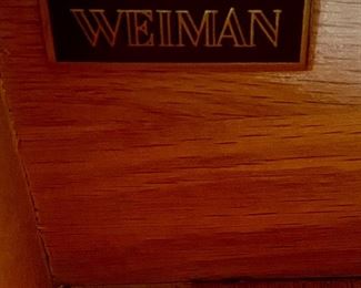 Lot 9095. $275.00. Weiman Pickled Oak Side Board and Hutch.  Sideboard has three pull out drawers, scalloped trim below that and a base open shelf above the leg knobs and it appears to have a couple stencils .  Hutch has same Scalloped feature below the top of the unit, and two shelves and sits right on the sideboard.  I believe it might have a little water damage on the lower shelf. Sideboard measures 64"w x 20"d x 32.5" tall.  Hutch measures 63" w x 12"deep x 38"tall